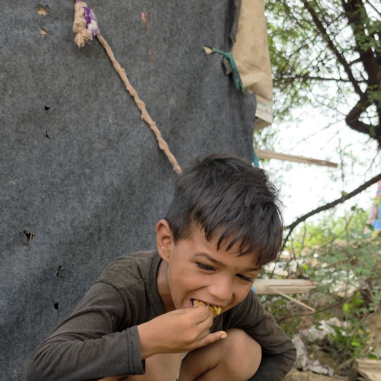 भोजन खाकर हंसता एक बच्चा
