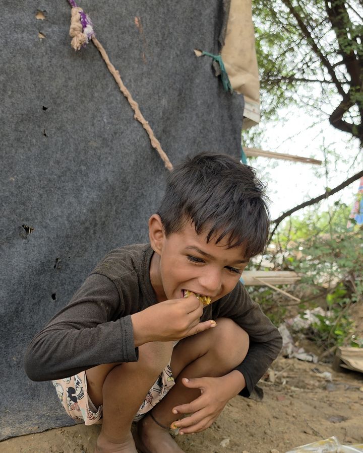 भोजन का आनंद लेता एक हंसता हुआ बच्चा