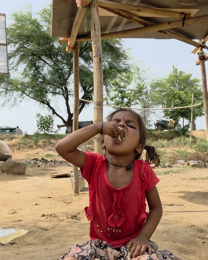 चाव से खाना खाती एक बच्ची